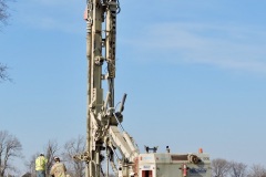 March 2021 - Workers drill a casing for a pile that will be used to support the embankment during construction of an abutment for the southbound U.S. 1 bridge over the Turnpike.